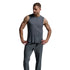 A man modeling a dark gray sleeveless athletic tank top and matching gray jogger pants, standing against a light gray studio background.