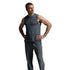A man modeling a dark gray sleeveless athletic top and matching gray jogger pants, paired with beige sneakers, against a light gray studio background.
