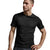 A man wearing a black short-sleeve athletic t-shirt and dark gray shorts, posing against a light gray studio background.