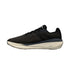 Black trainer with beige sole on a white background