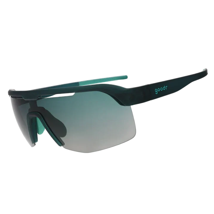 Sunglasses with black frame and green-tinted lenses on a white background