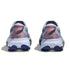 Back view of a pair of sneakers with a white sole and colorful design on a white background