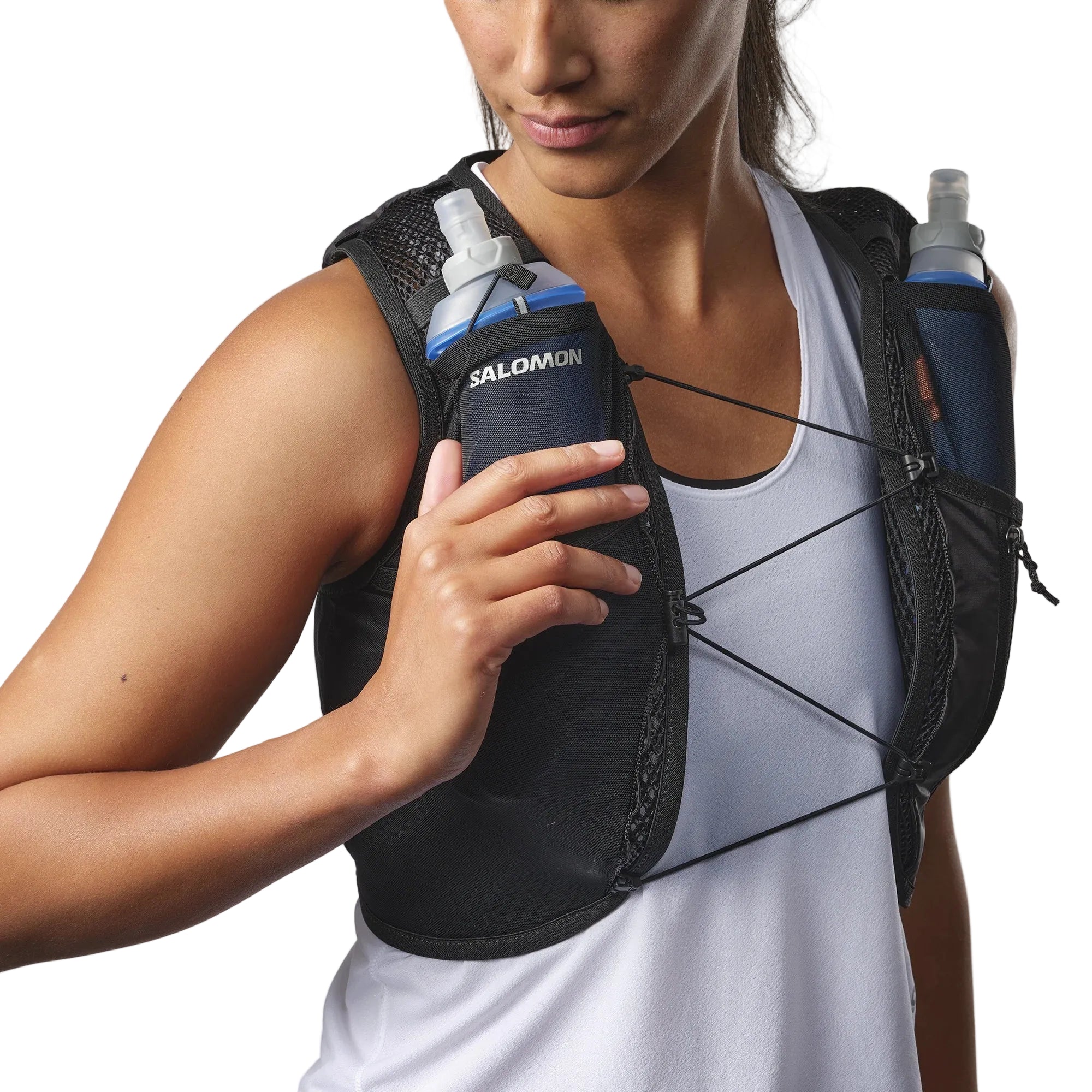 Person wearing a Salomon running vest with water bottles on a plain background