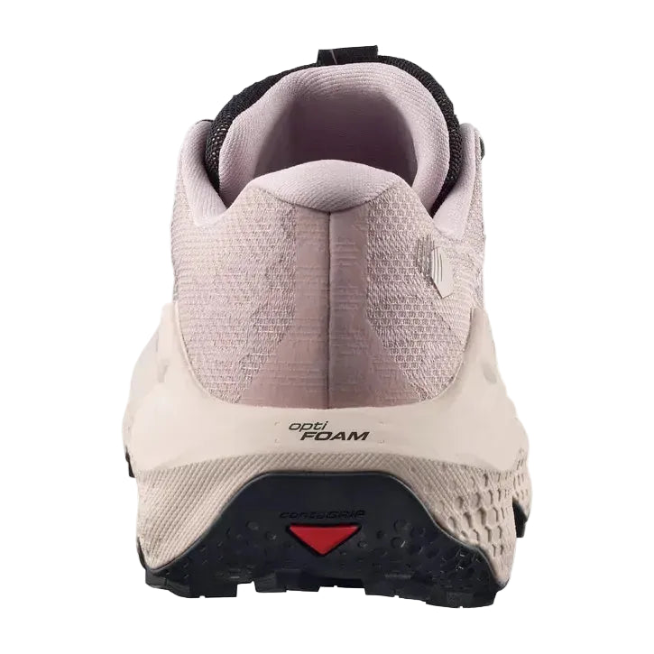 A close-up rear view of a trail running shoe in light pink and off-white, featuring a black outsole and a small red accent.