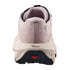 A close-up rear view of a trail running shoe in light pink and off-white, featuring a black outsole and a small red accent.