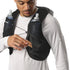 Person wearing a black hydration vest with water bottles and snacks.