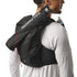 Person wearing a black Salomon running backpack with water bottles on a white background