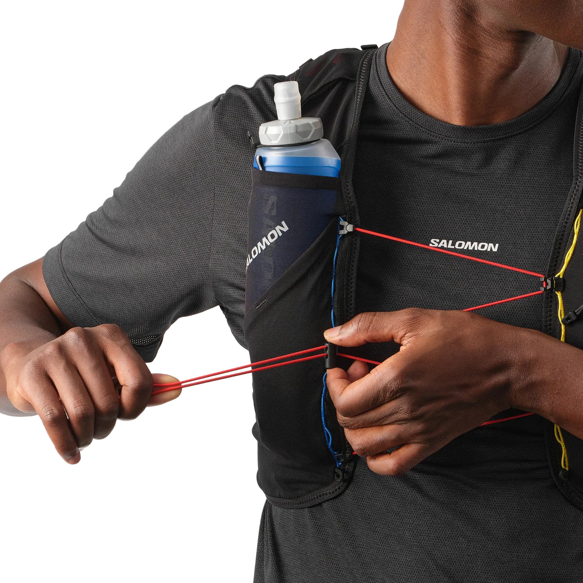 Person wearing a Salomon hydration pack with a bottle on a white background