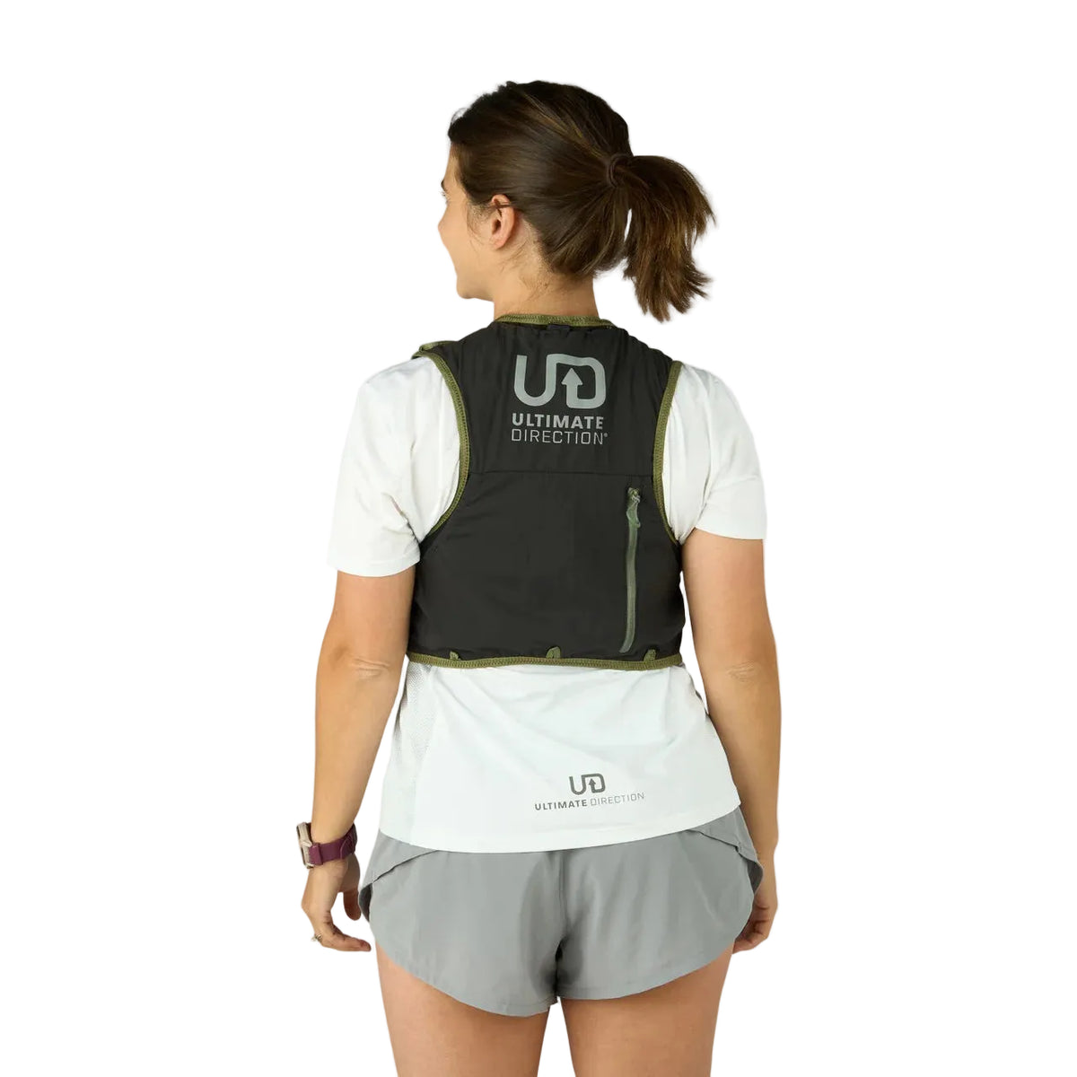 Person wearing a black Ultimate Direction vest on a light gray background