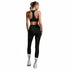 Person wearing black athletic leggings and sports bra on a gray background