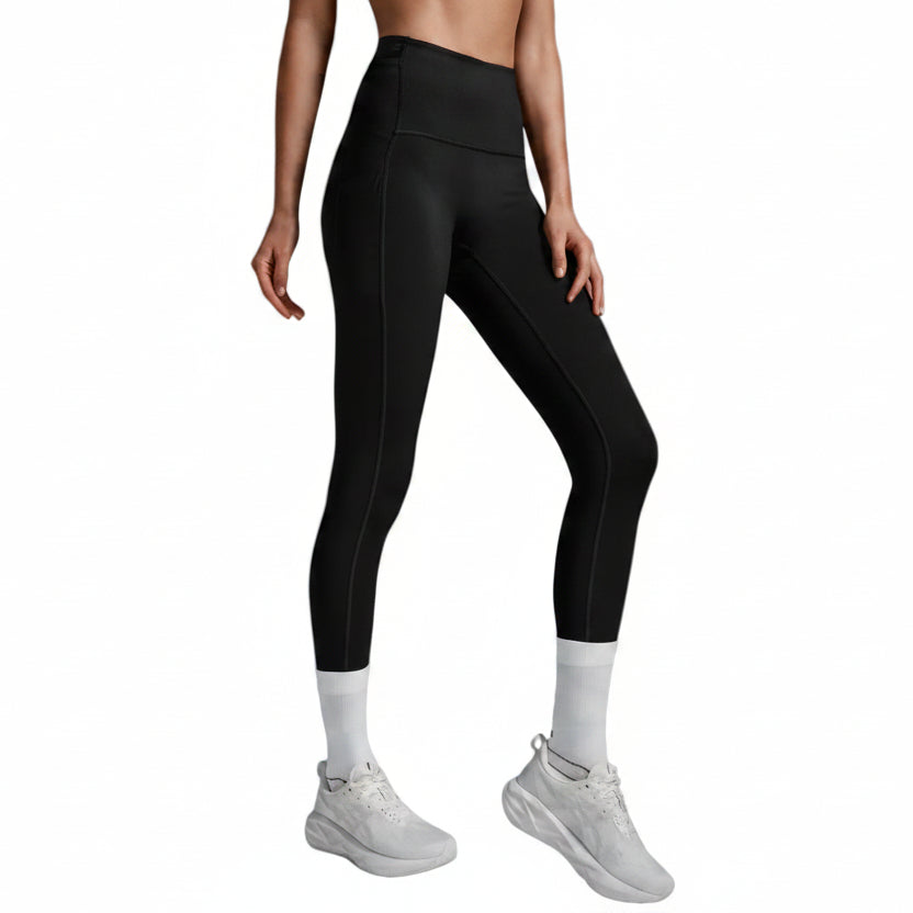 A model wearing black high-waisted athletic leggings, white crew socks, and white sneakers, shown from the waist down against a light gray studio background.