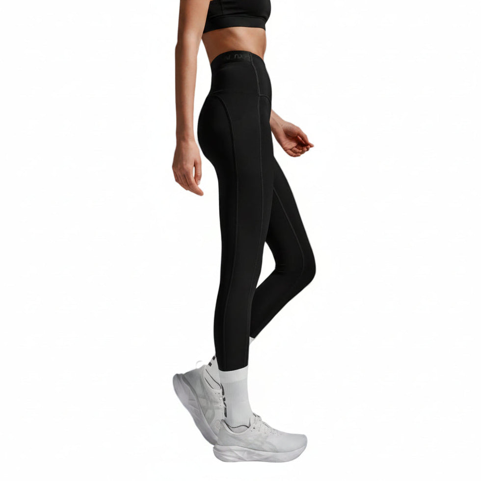 Person wearing black leggings and white sneakers on a light gray background