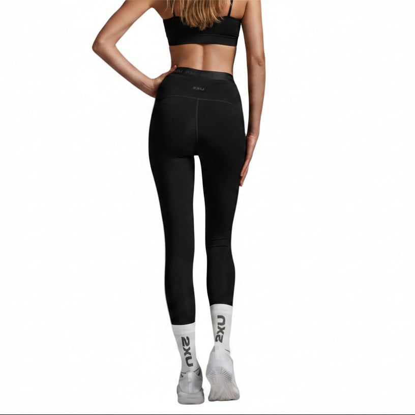 Person wearing black leggings on a gray background