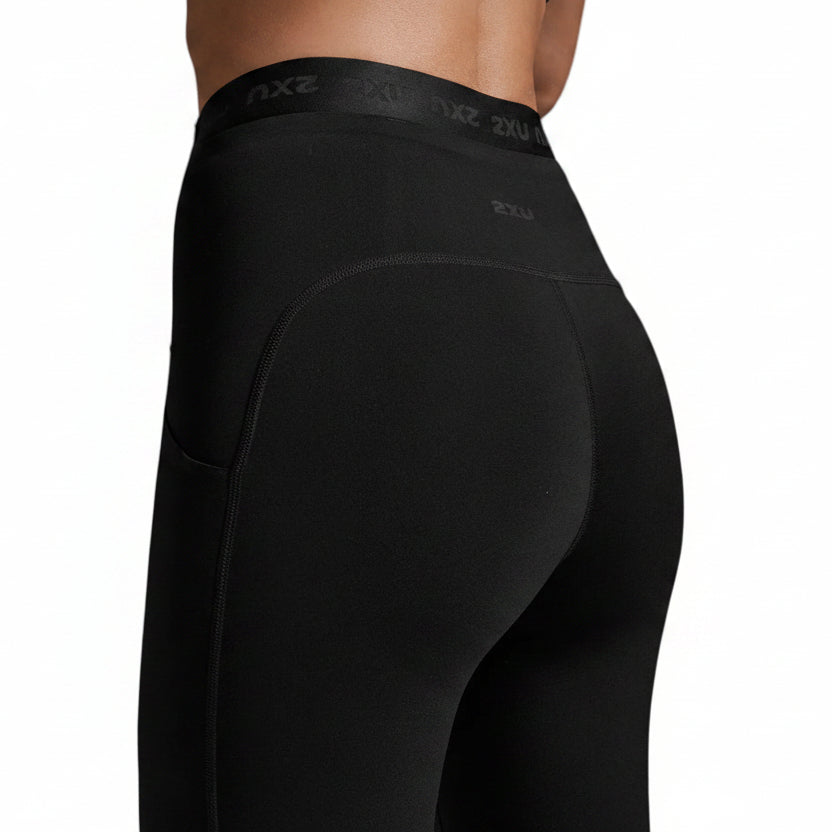 Close-up rear view of a person wearing black high-waisted athletic leggings with subtle 2XU branding on the upper back.