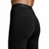 Close-up rear view of a person wearing black high-waisted athletic leggings with subtle 2XU branding on the upper back.