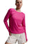 A model wearing a vibrant pink long-sleeve crewneck athletic top and off-white shorts, photographed against a neutral gray studio background.