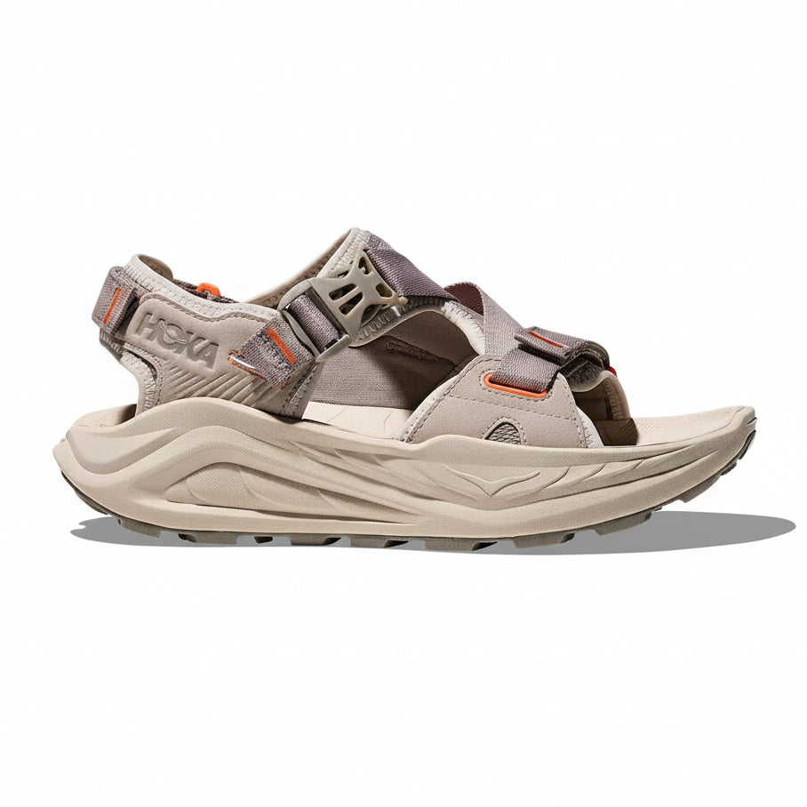 Tan sandal with 'Hoka' branding on a white background